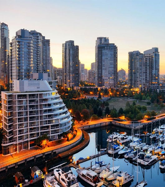 Vancouver harbor view with urban apartment buildings and bay boat in Canada